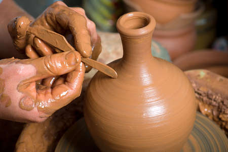 hands of a potter, creating an earthen jar on the circleの写真素材