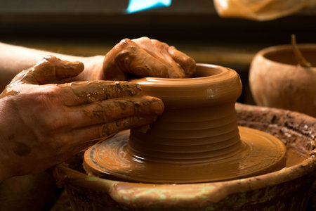 hands of a potter, creating an earthen jar