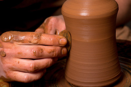 hands of a potter, creating an earthen jar