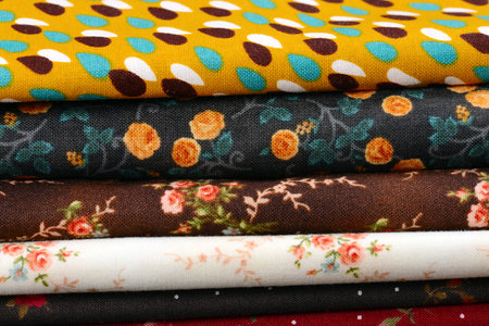 heap of cloth fabrics on wooden table