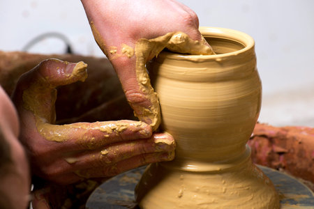 hands of a potter, creating an earthen jar