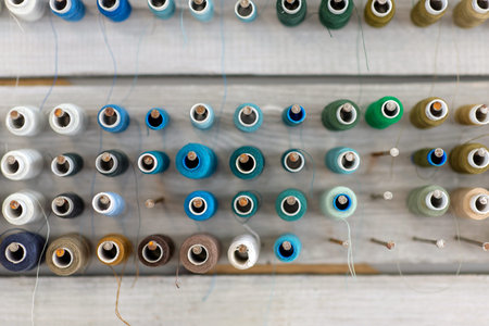 Bobbins with colorful threads on old wooden table background, Sewing background