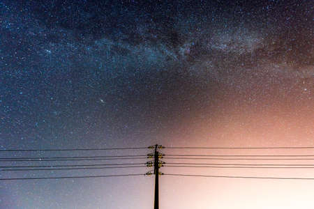 abstract night sky with milky way and star over the silhouette power lineの写真素材