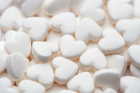Pharmacy theme. White pills in the form of hearts on white backgroundの写真素材