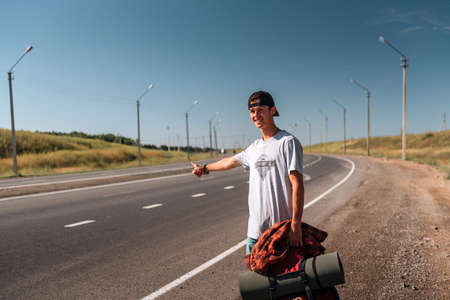 Travel man hitchhiking. Backpacker on road.の写真素材
