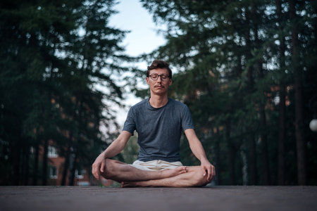 Man practicing meditation in cityの写真素材