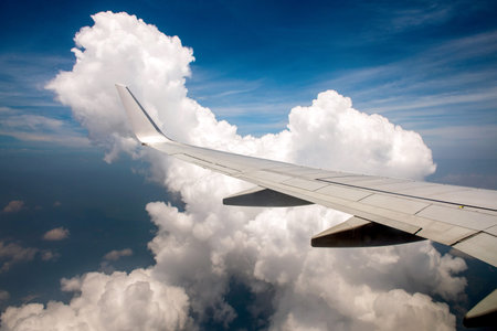 Wing of airplane in cloudy sky.