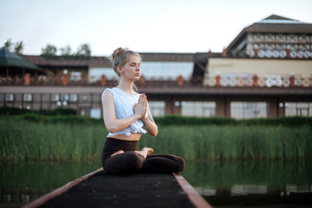 Girl practice yoga early morning on pier.