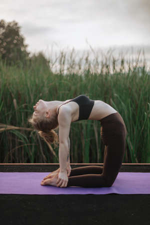 Girl practice yoga early morning on pier.の写真素材