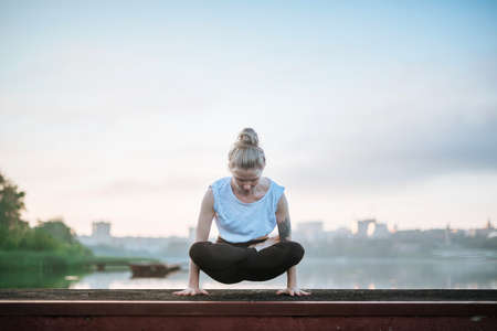Girl practice yoga early morning on pier.の写真素材