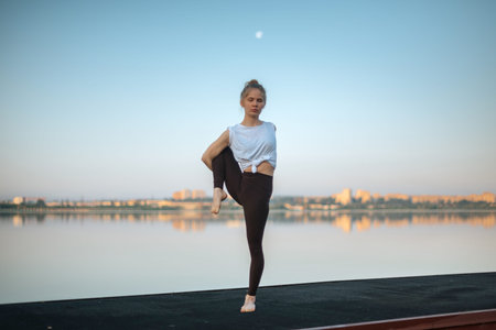 Girl practice yoga early morning on pier.