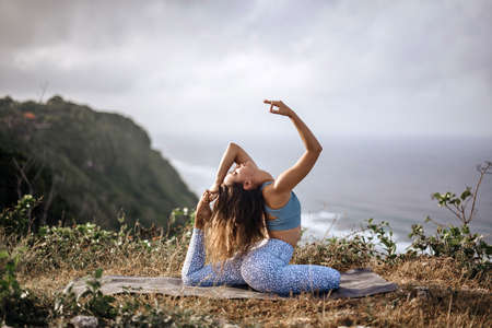 Girl practice yoga near oceanの写真素材