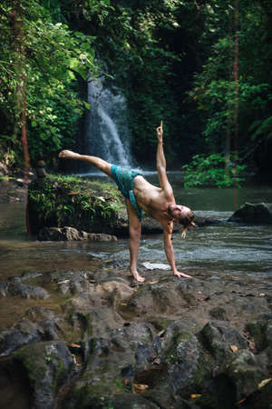Yoga practice and meditation in nature. Man practicing near river.の写真素材