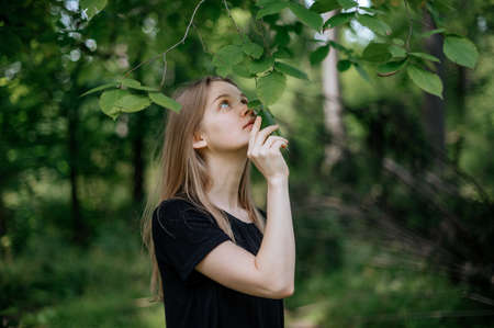 Practice of meditation and interaction with nature. Girl in green forest.の写真素材