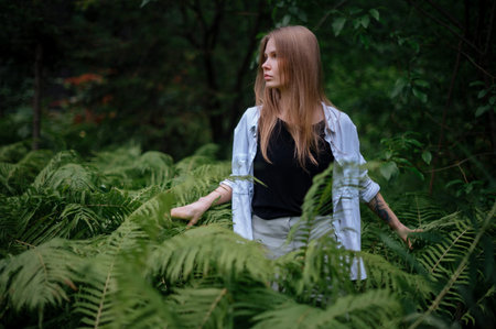 Practice of meditation and interaction with nature. Girl in green forest.