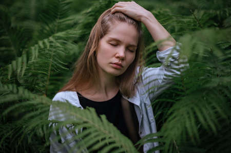 Practice of meditation and interaction with nature. Girl in green forest.の写真素材