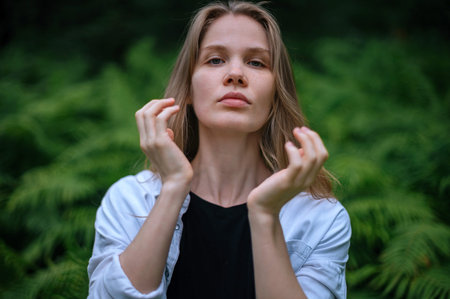 Practice of meditation and interaction with nature. Girl in green forest.
