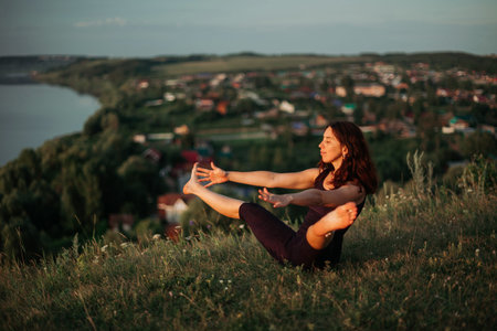 Yoga practice and meditation in nature in sunrise. Woman practicing near big river Kama