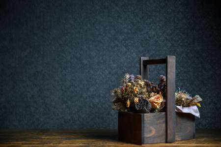 Composition of dried flowers in a wooden basket on dark backgroundの写真素材