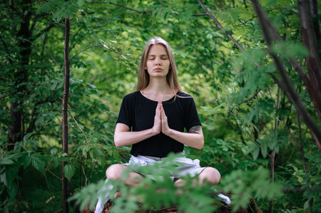 Practice of meditation and interaction with nature. Girl in green forestの写真素材