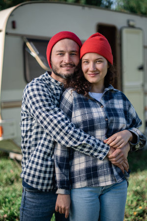 Romantic couple spending time together near trailer home. Handsome bearded man and beautiful woman...