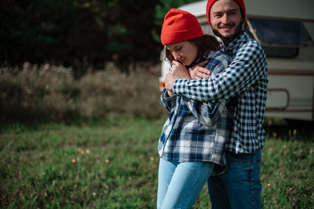 Romantic couple spending time together near trailer home. Traveling together with motor home.