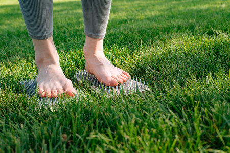 The girl stands on the nails. Sadhu wooden board for yoga practice. Nailing practiceの写真素材