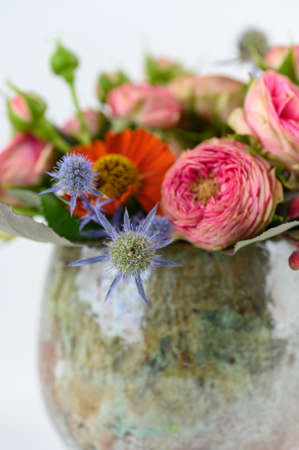 Flowers bouquet in glazed vase on white backgroundの写真素材