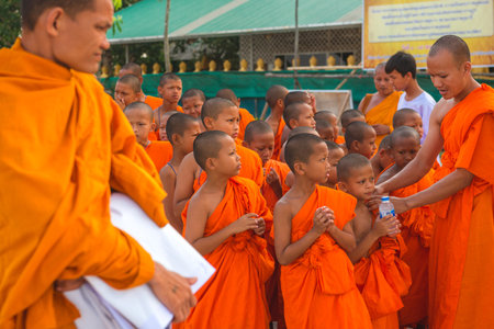 Young buddhists in orange clothes near the Big Buddha Temple in Phuket in Thailand. April 28, 2019.のeditorial素材