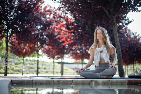 Girl with Namaste. practice meditation in park with red trees on a background. Text spaceの写真素材