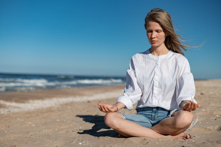 Girl practice meditation on the beach. With space for text or designの写真素材