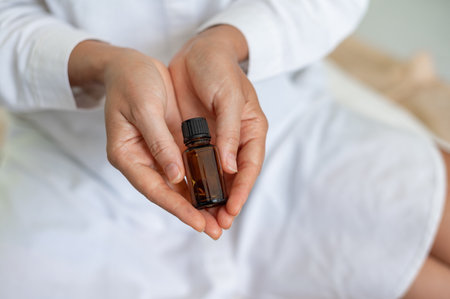 Female scientist in white medical uniform with mock up glass cosmetic jar in handsの写真素材