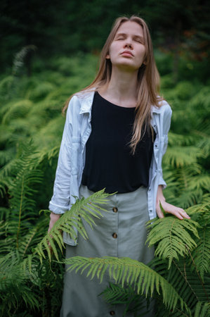 Girl in green forest. Practice of meditation and interaction with natureの写真素材