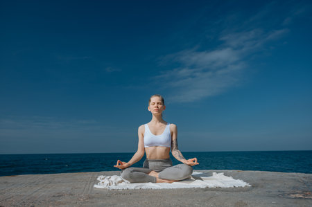 Yoga practice and meditation in nature. Woman practicing near Black sea.の写真素材