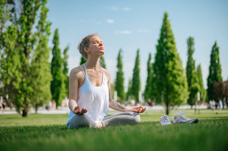Beautiful girl practice yoga outdoor. Meditation in parkの写真素材
