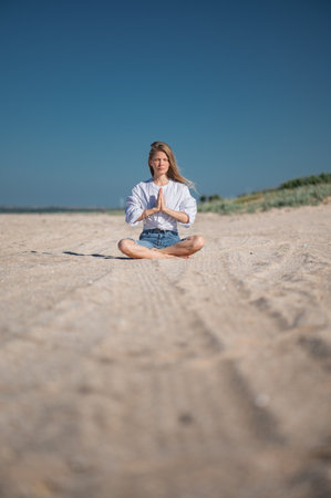 Girl practice meditation on the beach. With space for text or designの写真素材