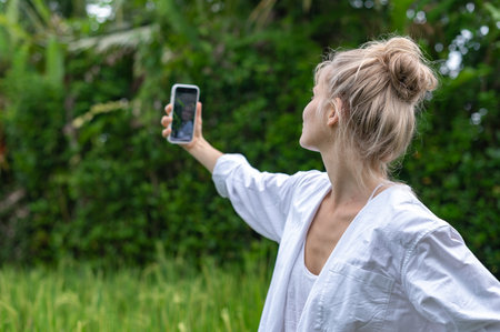 Girl make a selfie outdoor in green rice terraceの写真素材