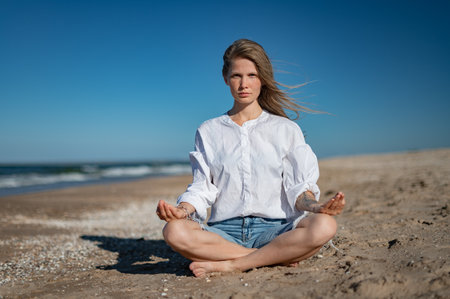 Girl practice meditation on the beach. With space for text or designの写真素材