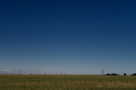 Wind Turbines Windmill Energy Farm on green field and blue skyの写真素材