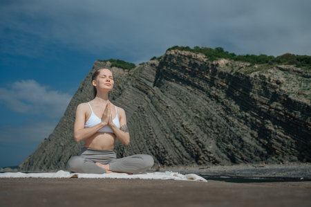 Yoga practice and meditation in nature. Woman practicing near Black sea.の写真素材