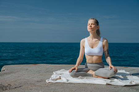 Yoga practice and meditation in nature. Woman practicing near Black sea.の写真素材