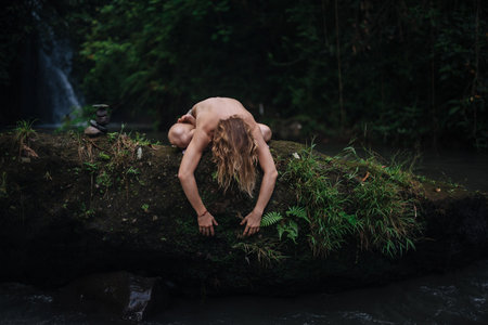 Yoga practice and meditation in nature. Man practicing near riverの写真素材