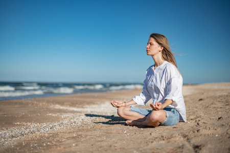 Girl practice meditation on the beach. With space for text or designの写真素材