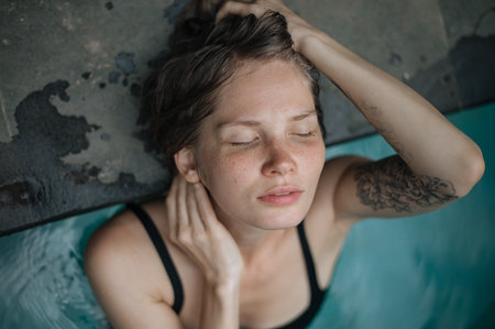 Beautiful girl enjoy in swimming pool with closed eyes. Close upの写真素材