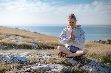 Girl practicing yoga meditation outdoorsの写真素材