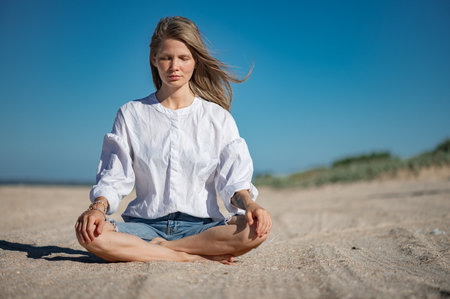 Girl practice meditation on the beach. With space for text or designの写真素材