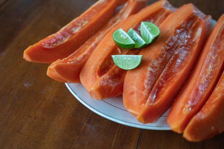 Sliced papaya with lime on tableの写真素材
