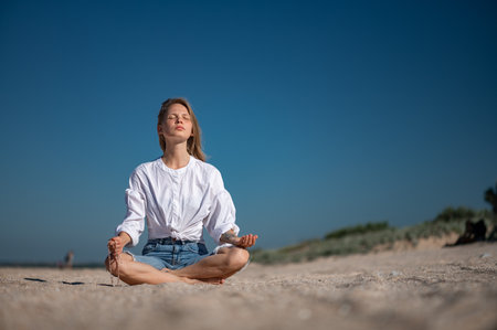 Girl practice meditation on the beach. With space for text or designの写真素材