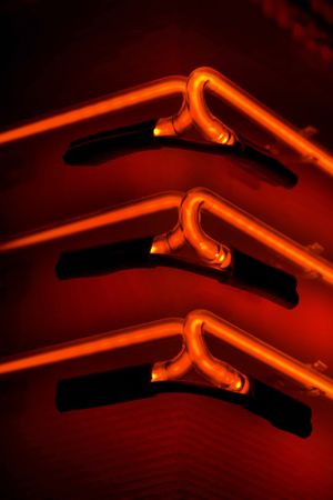 Close-up shot of three orange club neon lampsの写真素材