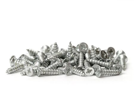 Small pile of metal screws isolated over white backgroundの写真素材